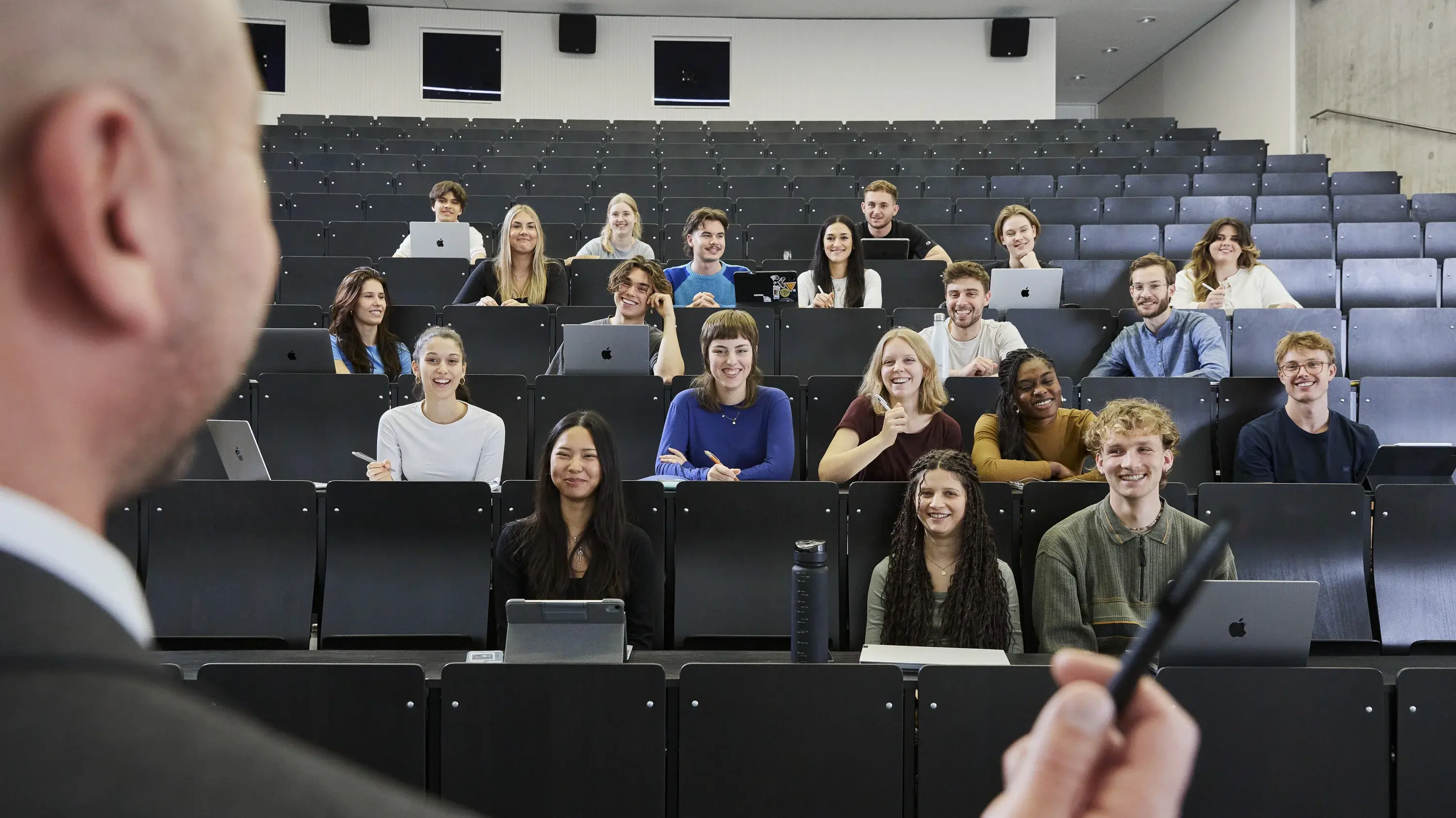 Ein Professor mit seinen Studierenden in der Vorlesung.